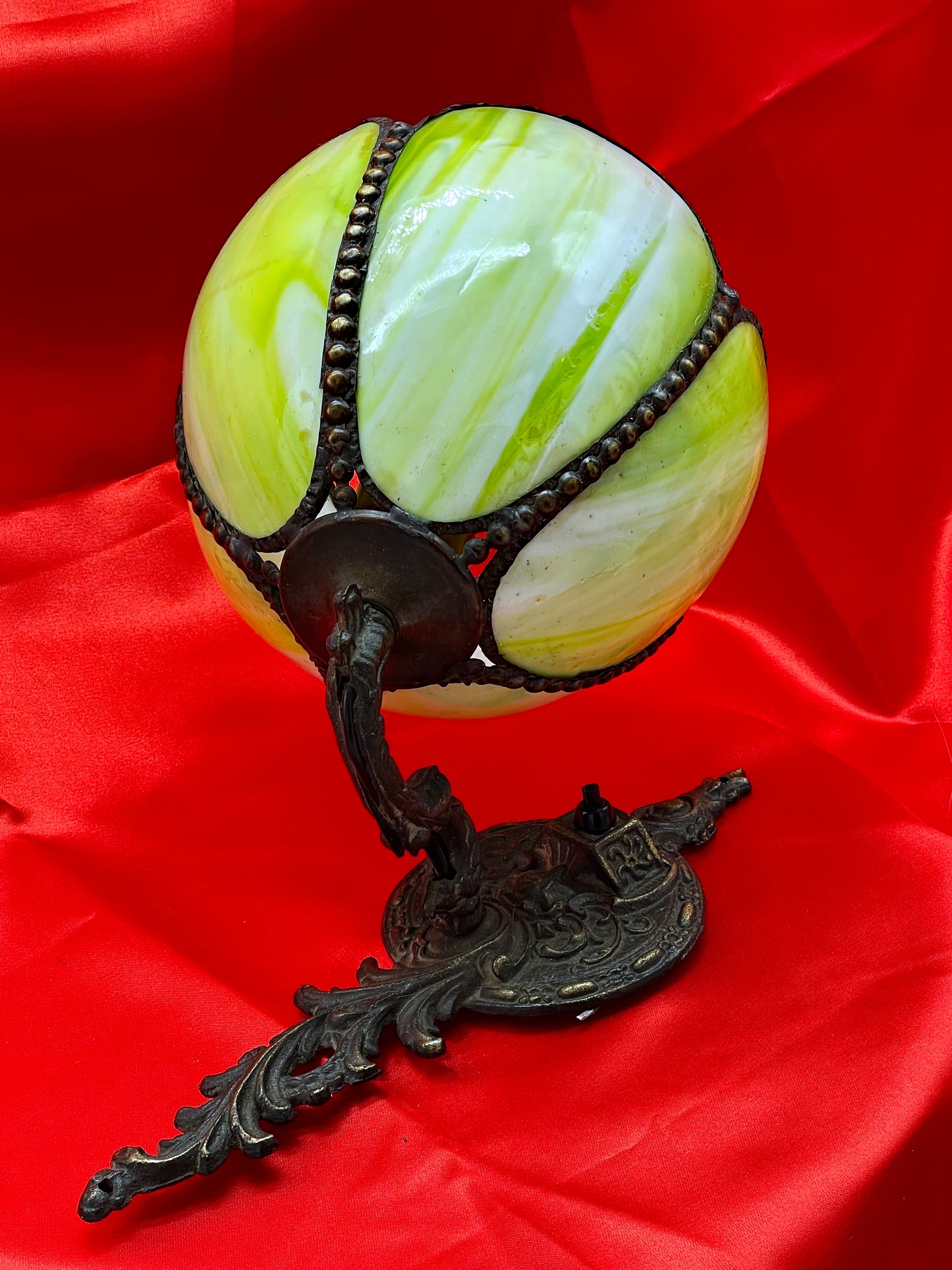 Art Nouveau bronze sconce showing the scrolling arm and decorative cast backplate