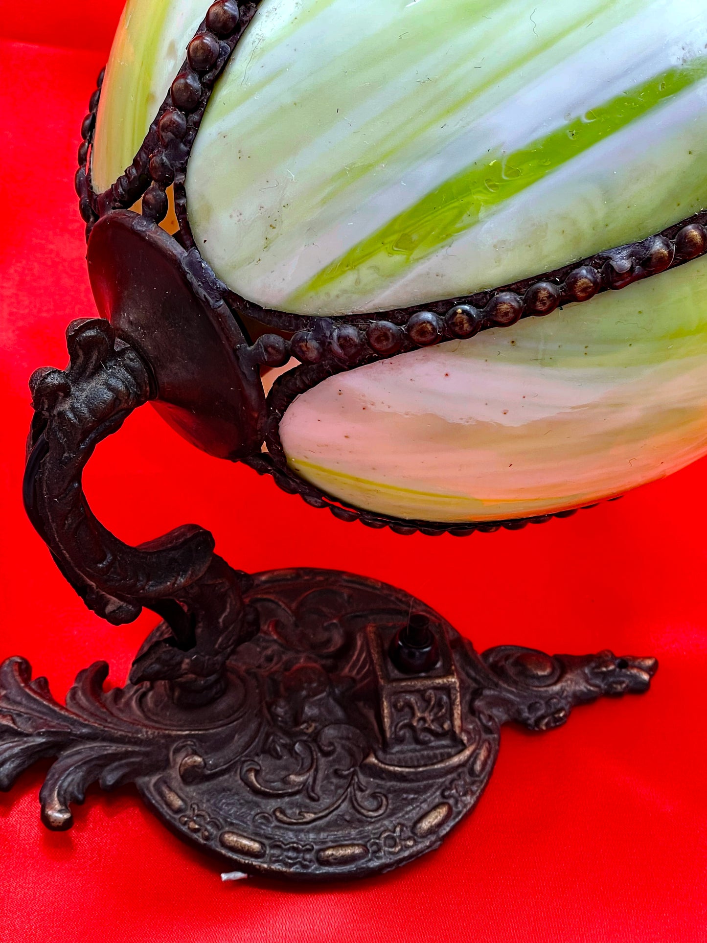 Close detail of the bronze beaded trim where the glass meets the holding arm