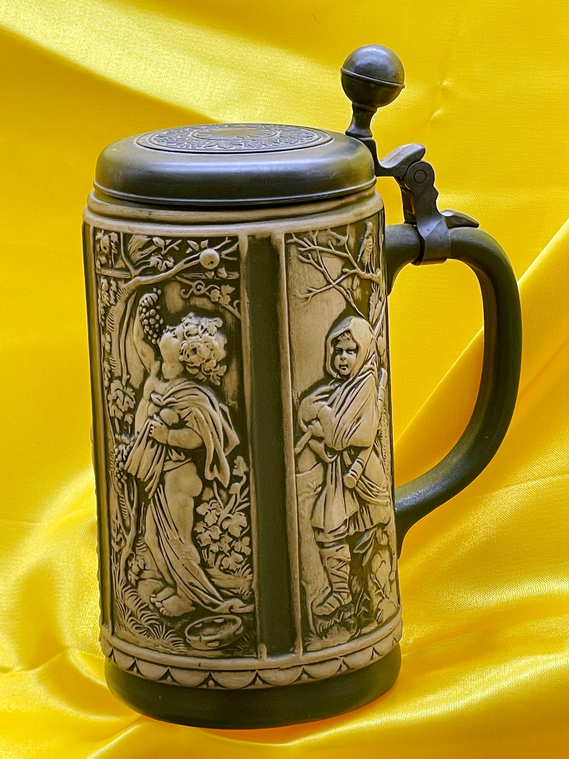 Relief German stein showing seasonal figure and pewter thumb-lift, side view