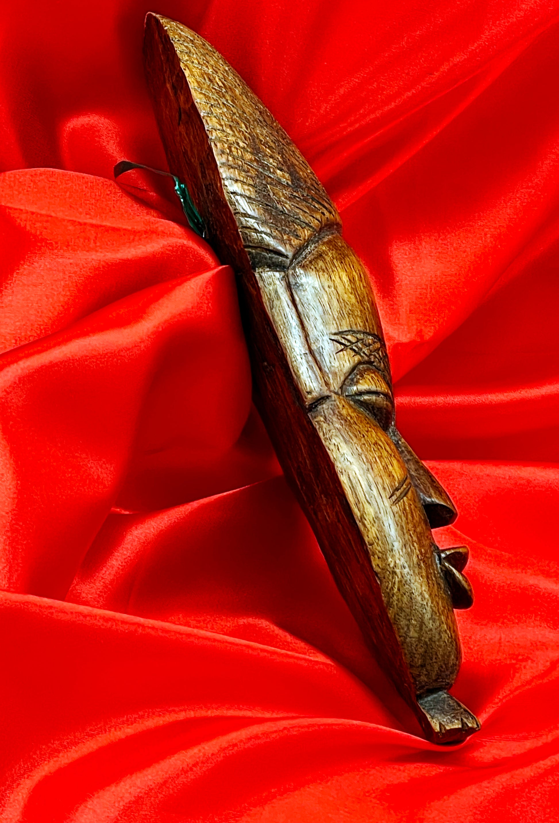 Side profile of the African wood mask showing the carved depth and relief