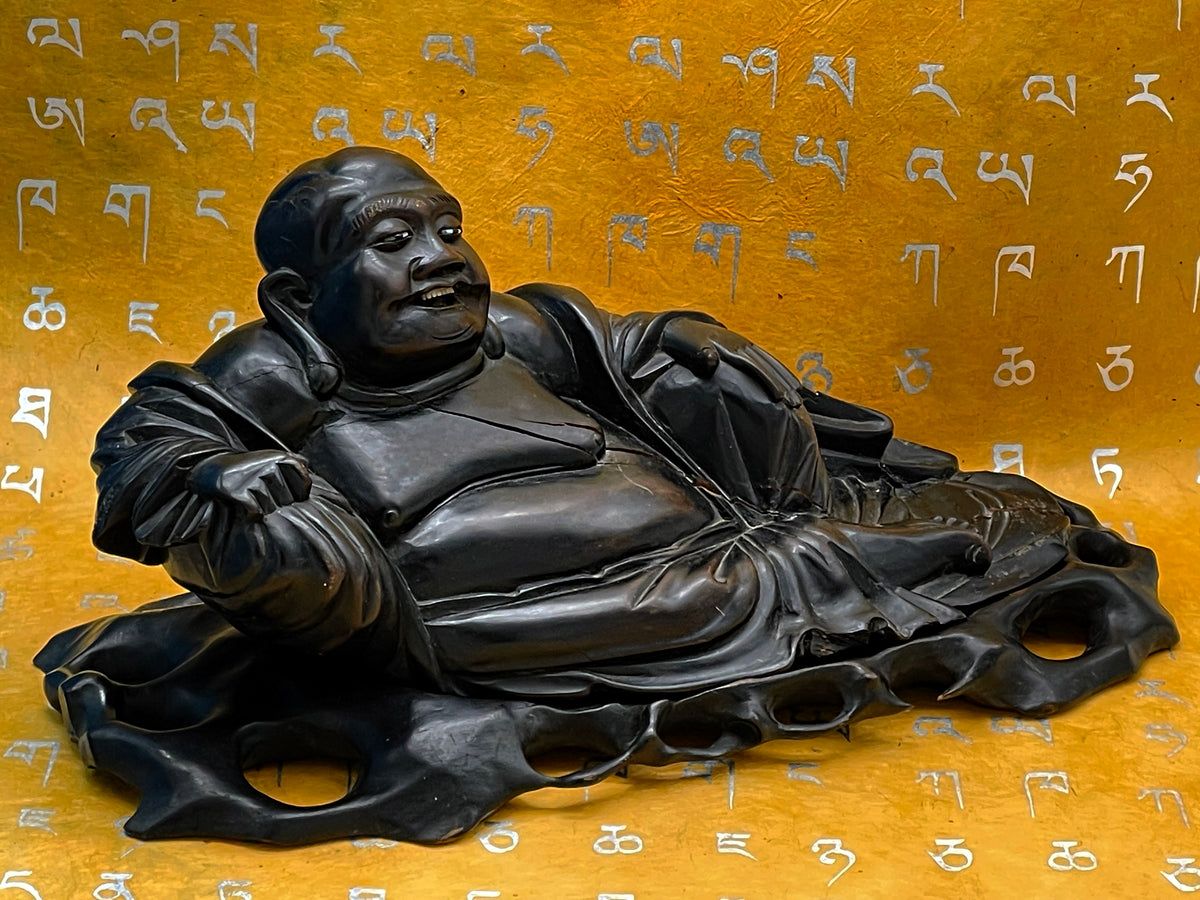 Antique Chinese carved ebony reclining Buddha on original openwork base, front view on golden backdrop