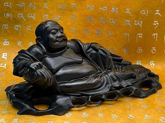 Antique Chinese carved ebony reclining Buddha on original openwork base, front view on golden backdrop