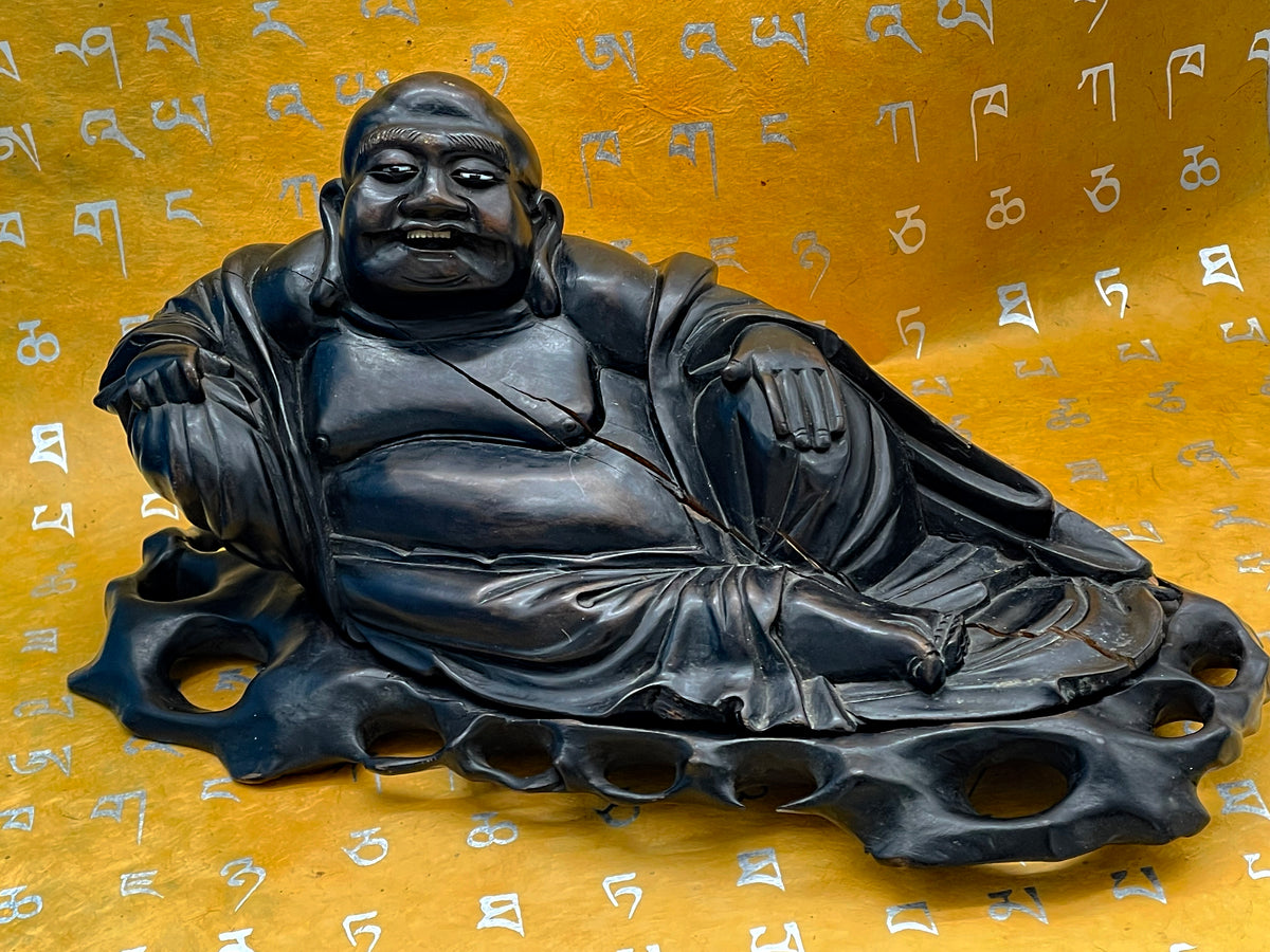 Reclining ebony Buddha from the right side showing bone inlaid eyes and openwork base
