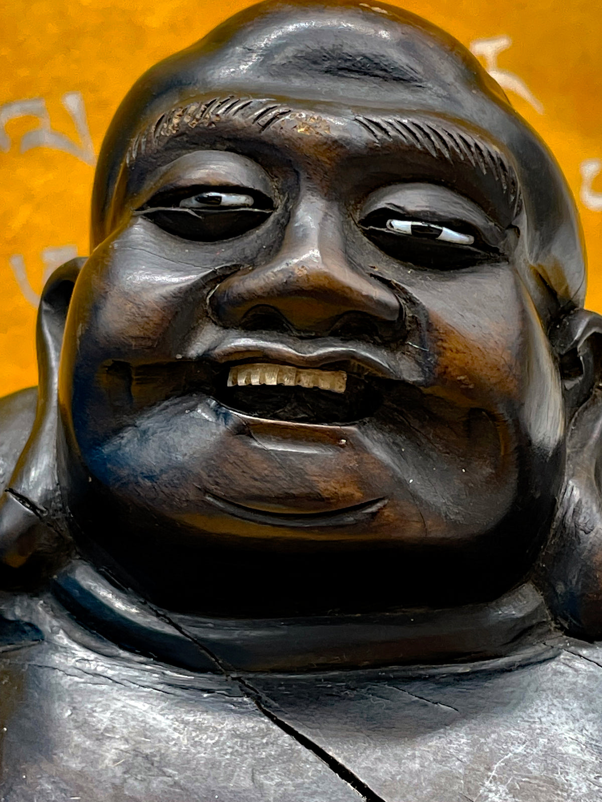 Detail of the Buddha face showing bone teeth and carved features