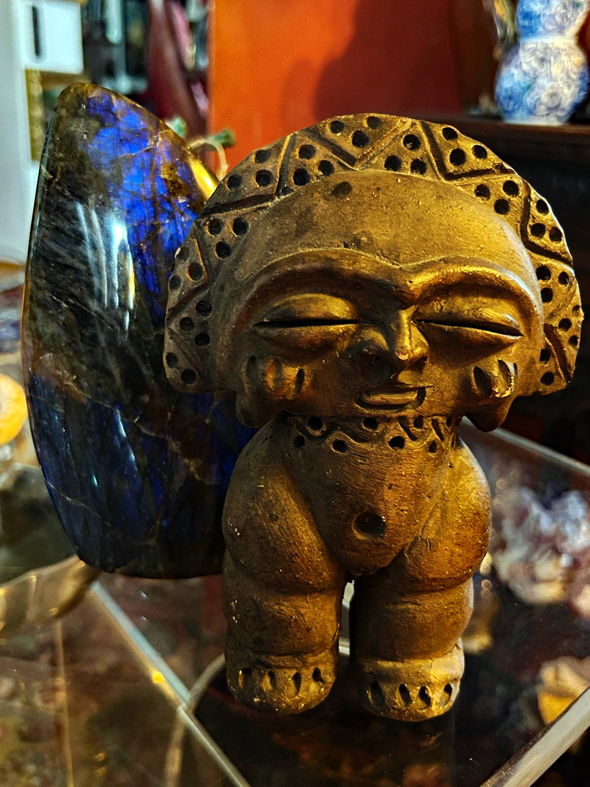 Taino-style stone zemi idol figure with incised headdress, front view, golden patina
